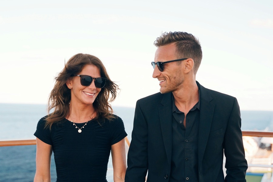 Stylish couple holding hands on the deck of a cruise ship